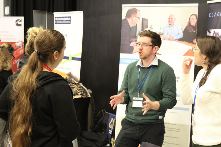 Students speak to a careers advisor at job fair