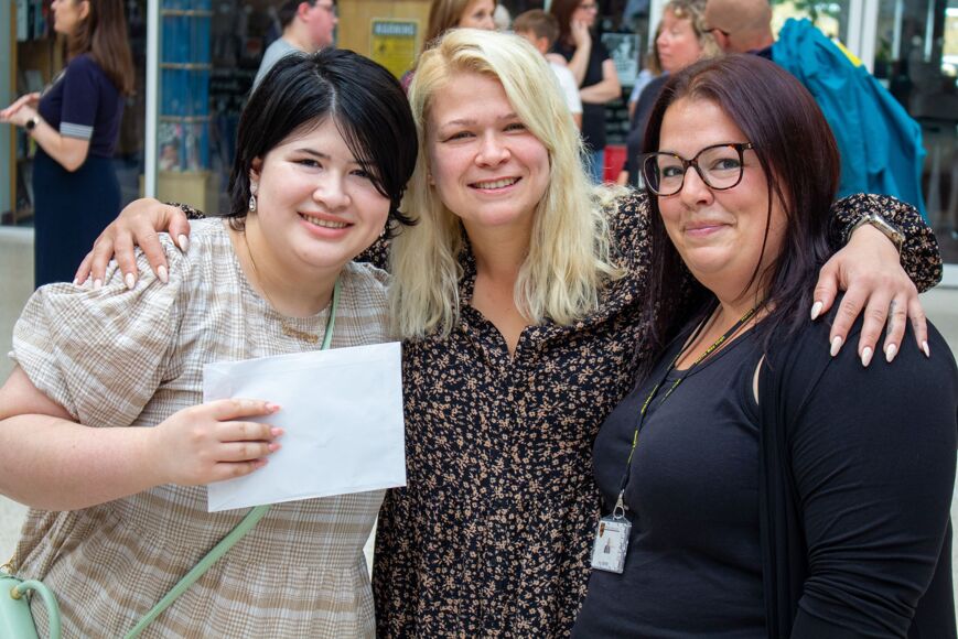 Female student celebrates their results with mother and member of staff