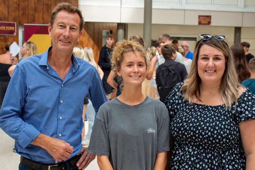 Photograph of student with staff members on results day